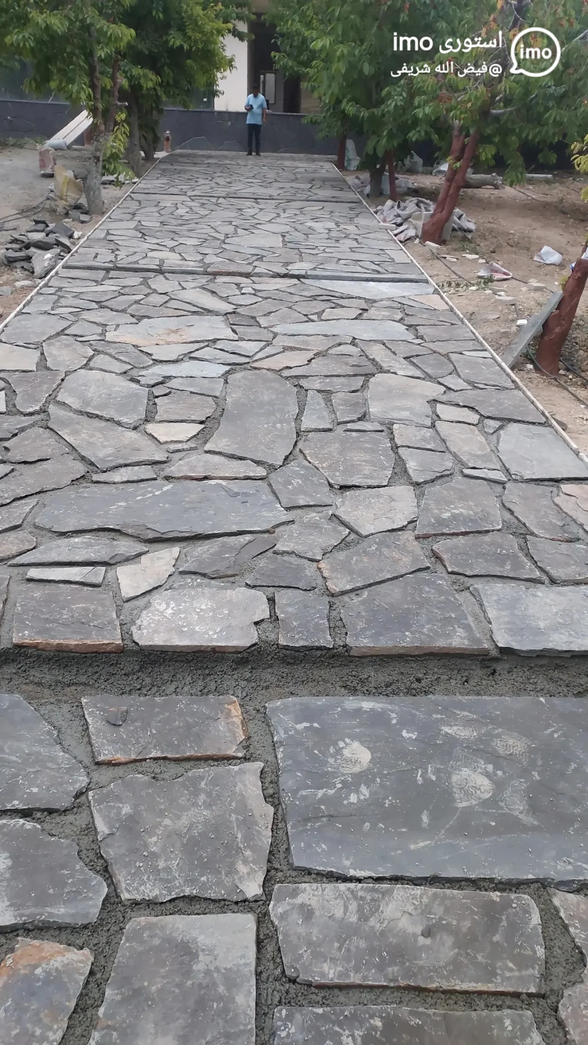 مسیر پیاده‌روی زیبا در باغ، کف‌سازی شده با سنگ لاشه تخت و منظم، مناسب برای عبور و مرور.